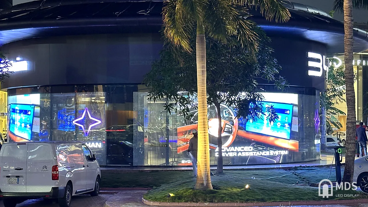 BYD showroom in Jeddah: transparent LED facade showing the in-car display and Advanced Driver Assistance System at night