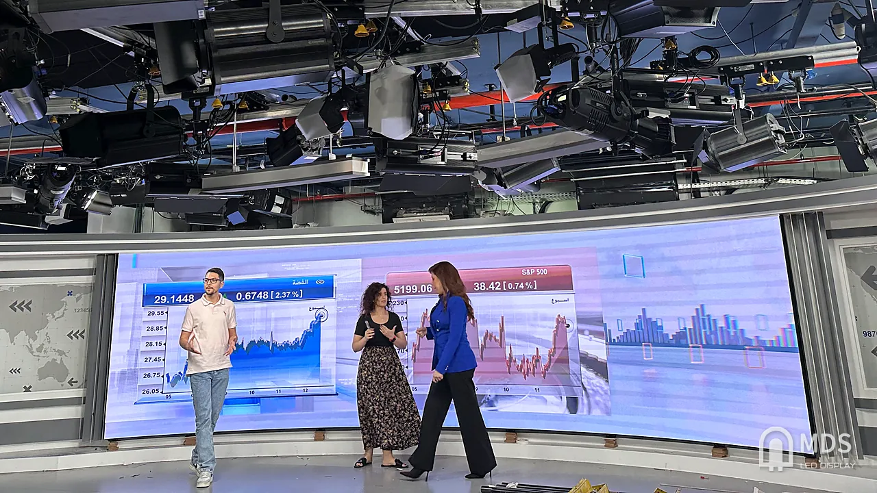 CNBC Arabia studio on air: curved fine-pitch LED wall behind three presenters, no flicker on camera