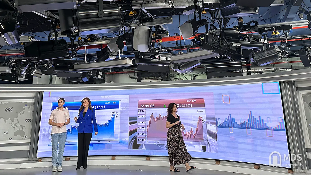 CNBC Arabia live studio: presenters in front of the curved MDS P1.56 flexible LED wall (7,680 Hz) showing market charts